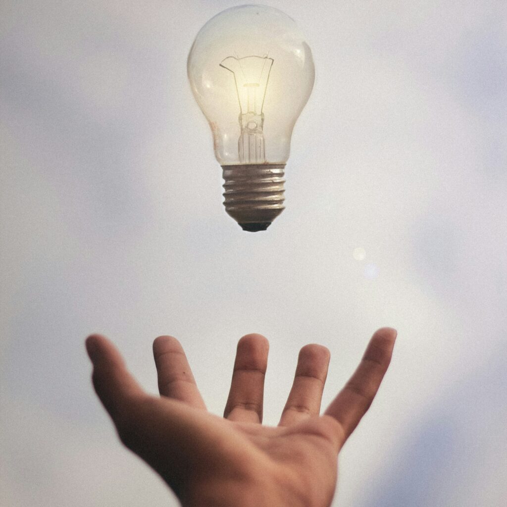 A lightbulb floating over a hand signifying that a person has an idea